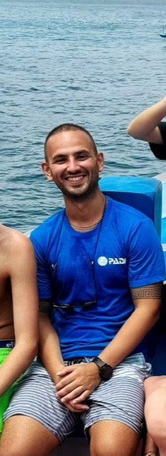 Dimitrios V. Smirnich in a blue PADI shirt on a dive boat